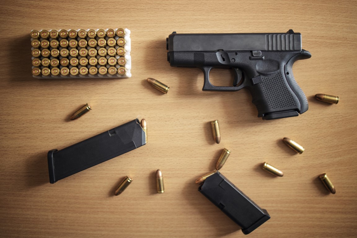 gun with box ammunition bullets wooden wall Medium